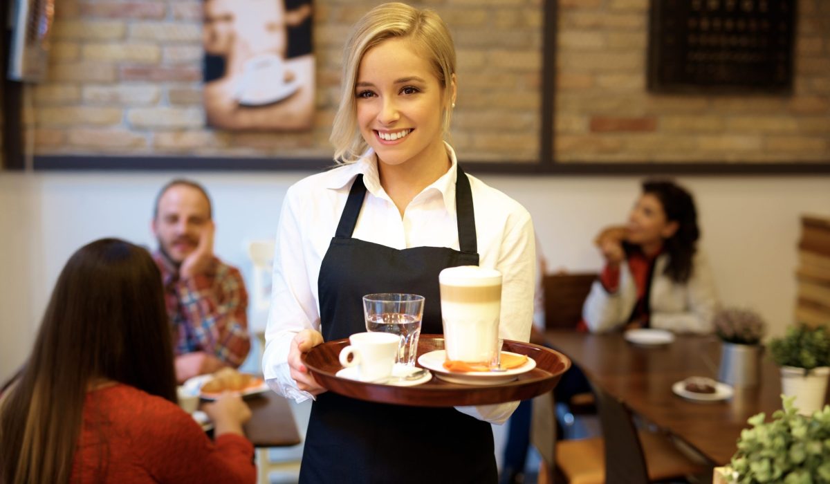Happy waitress holding tray Hospitality Recruitment